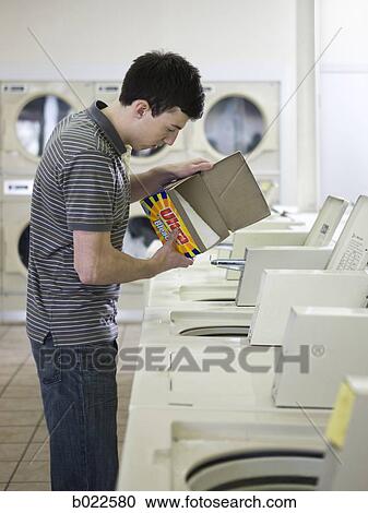 man doing laundry at a laundromat View Large Photo Image Stock Image - man doing laundry at a laundromat. Fotosearch