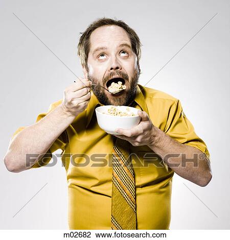 Stock Image - man eating a bowl of cereal. Fotosearch