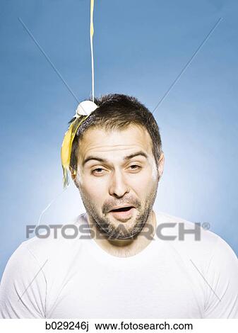 Stock Image - man getting an egg dropped on his head. Fotosearch