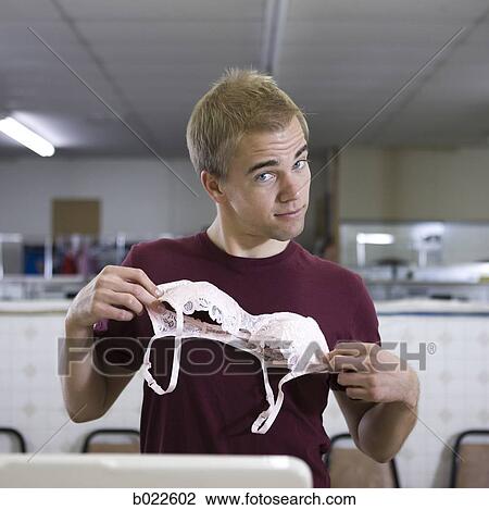 man holding up a bra View Large Photo Image Stock Image - man holding up a bra. Fotosearch