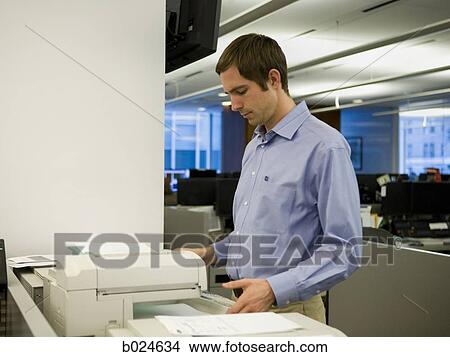 Picture - man in a blue shirt at work. Fotosearch