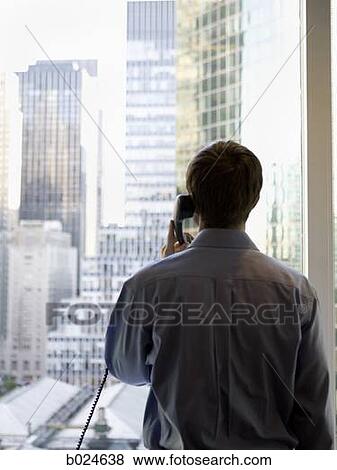 man in a blue shirt on the phone View Large Photo Image Stock Photo - man in a blue shirt on the phone. Fotosearch
