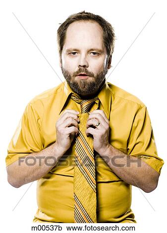 Stock Image - man in a yellow shirt and tie fixing his tie. Fotosearch