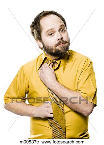 Stock Image - man in a yellow shirt and tie fixing his tie. Fotosearch