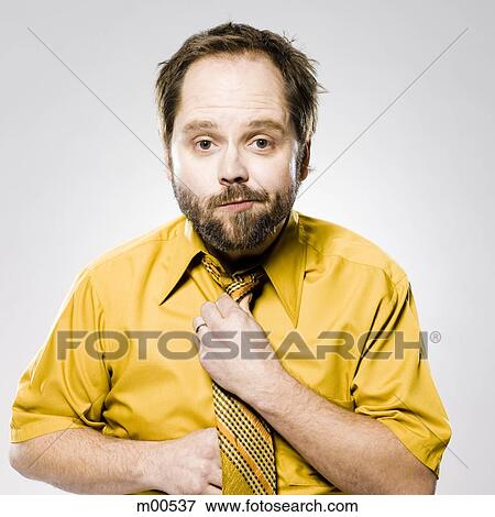 man in a yellow shirt and tie fixing his tie View Large Photo Image Stock Photo - man in a yellow shirt and tie fixing his tie. Fotosearch