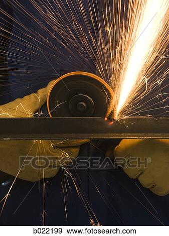 Stock Photo - man in blue coveralls with a power grinder. Fotosearch