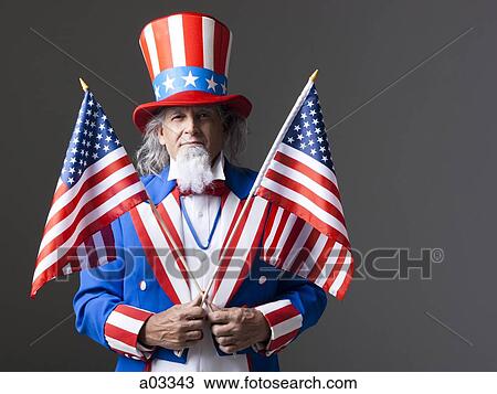 Man in Uncle Sam's costume holding american flags, studio shot View Large Photo Image Stock Image - Man in Uncle Sam's costume holding american flags, studio shot. Fotosearch