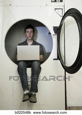 man inside a commercial clothes dryer at a laundromat View Large Photo Image Stock Image - man inside a commercial clothes dryer at a laundromat. Fotosearch