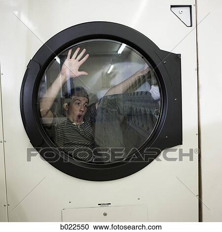 man inside a commercial clothes dryer at a laundromat View Large Photo Image Stock Image - man inside a commercial clothes dryer at a laundromat. Fotosearch