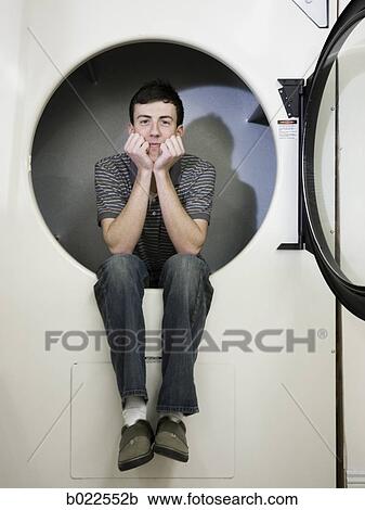 man inside a commercial clothes dryer at a laundromat View Large Photo Image Stock Image - man inside a commercial clothes dryer at a laundromat. Fotosearch