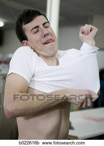 man putting on a shrunken t-shirt View Large Photo Image Stock Image - man putting on a shrunken t-shirt. Fotosearch