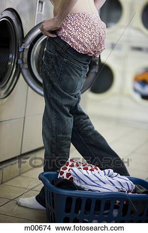 man putting on jeans at the laundromat View Large Photo Image Picture - man putting on jeans at the laundromat. Fotosearch