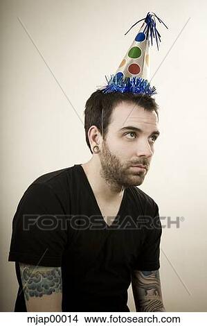 man wearing a party hat looking very depressed View Large Photo Image Picture - man wearing a party hat looking very depressed. Fotosearch