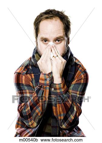 Stock Image - man wearing flannel blosing his nose. Fotosearch