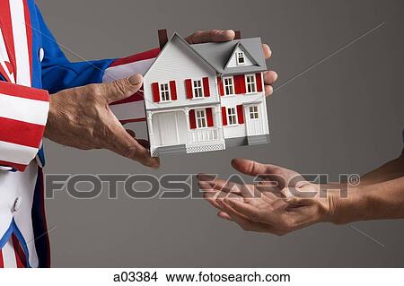 Man wearing suit with american flag giving model house View Large Photo Image Picture - Man wearing suit with american flag giving model house. Fotosearch