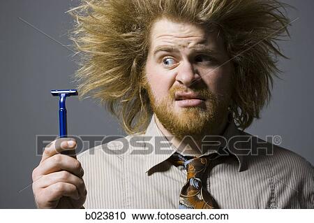 man with crazy hair holding a razor View Large Photo Image Stock Image - man with crazy hair holding a razor. Fotosearch