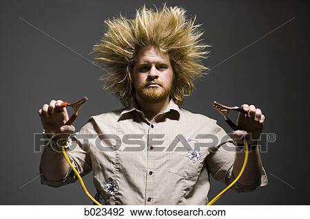 Stock Image - man with crazy hair holding jumper cables. Fotosearch