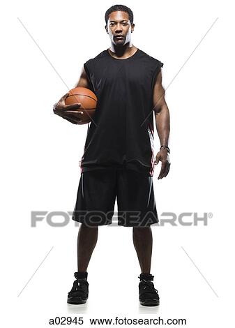Stock Photography - Mid adult man posing with basketball, portrait. Fotosearch