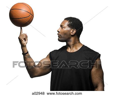 Stock Photo - Mid adult man spinning basketball in air. Fotosearch