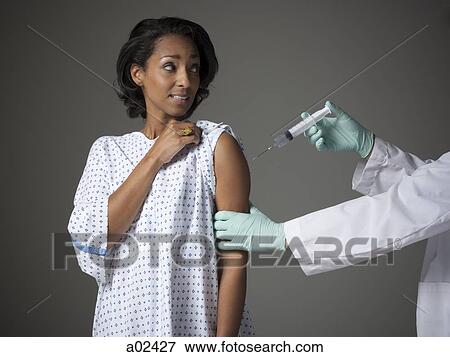 Mid adult woman receiving injection View Large Photo Image Stock Photo - Mid adult woman receiving injection. Fotosearch
