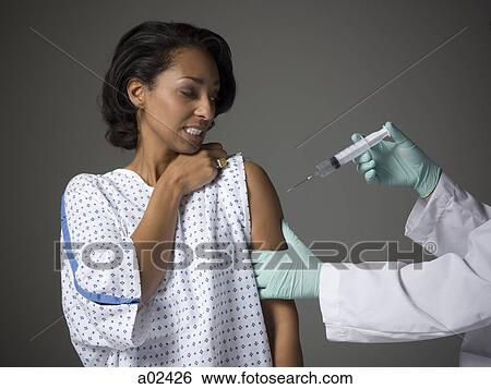 Mid adult woman receiving injection View Large Photo Image Stock Photograph - Mid adult woman receiving injection. Fotosearch