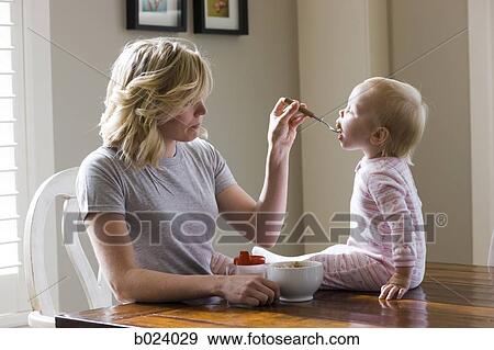 mother and baby girl at the breakfast table View Large Photo Image Stock Photo - mother and baby girl at the breakfast table. Fotosearch