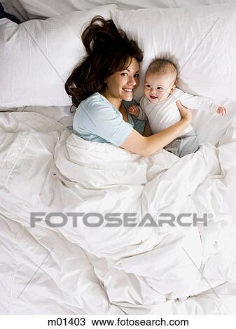 Stock Image - mother and baby in bed. Fotosearch