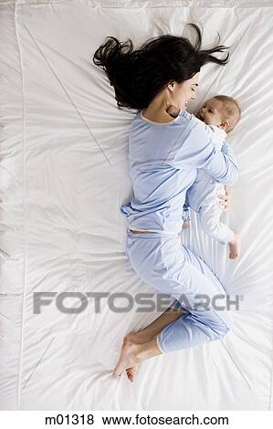 Stock Photo - mother and baby on a bed. Fotosearch