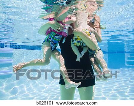 Stock Image - mother and children in a swimming pool. Fotosearch
