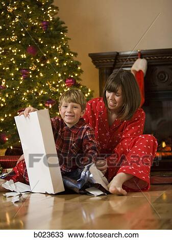 Stock Image - mother and son opening a christmas present. Fotosearch
