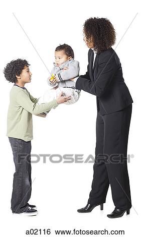 Mother passing baby boy (18-23 months) to son (8-9), studio shot View Large Photo Image Stock Photograph - Mother passing baby boy (18-23 months) to son (8-9), studio shot. Fotosearch