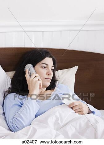 Orem, Utah, USA, young ill woman in bed talking on cordless phone View Large Photo Image Stock Photo - Orem, Utah, USA, young ill woman in bed talking on cordless phone. Fotosearch