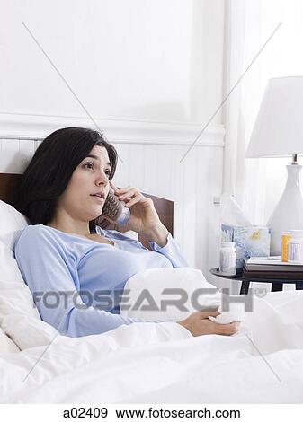 Orem, Utah, USA, young ill woman in bed talking on cordless phone View Large Photo Image Stock Photo - Orem, Utah, USA, young ill woman in bed talking on cordless phone. Fotosearch