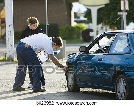 Stock Image - people looking at a car after an accident. Fotosearch