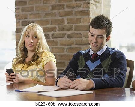 Stock Image - people using cell phones during a meeting. Fotosearch