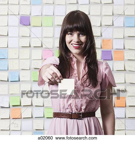 Portrait of young woman holding adhesive note View Large Photo Image Stock Image - Portrait of young woman holding adhesive note. Fotosearch