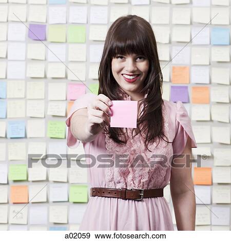 Portrait of young woman holding adhesive note View Large Photo Image Stock Photo - Portrait of young woman holding adhesive note. Fotosearch