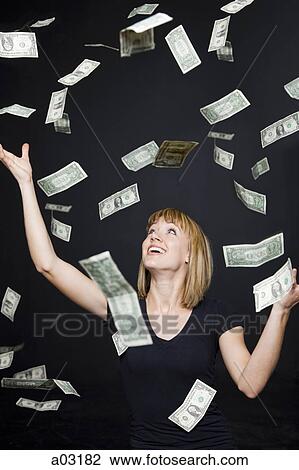 Stock Image - Portrait of young woman playing with banknotes, digital enhancement. Fotosearch