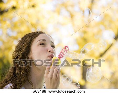 Provo, USA, Utah, Young woman blowing bubbles in front of colorful tree, portrait View Large Photo Image Stock Photo - Provo, USA, Utah, Young woman blowing bubbles in front of colorful tree, portrait. Fotosearch