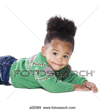 Stock Photo - Studio portrait of baby girl (18-23 months) lying on front. Fotosearch
