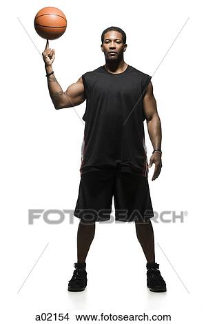 Picture - Studio portrait of basketball player balancing ball on finger. Fotosearch