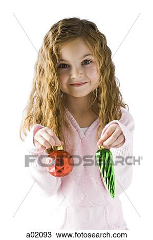 Studio portrait of girl (6-7) holding Christmas ornaments View Large Photo Image Stock Image - Studio portrait of girl (6-7) holding Christmas ornaments. Fotosearch