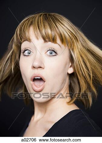 Stock Photograph - Studio portrait of shocked young woman. Fotosearch