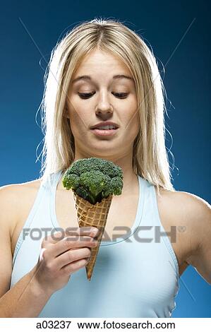 Studio portrait of young woman holding broccoli ice cream View Large Photo Image Stock Photo - Studio portrait of young woman holding broccoli ice cream. Fotosearch