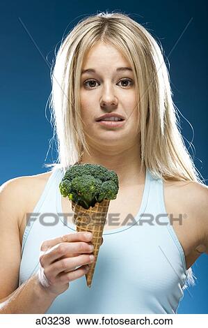 Studio portrait of young woman holding broccoli ice cream View Large Photo Image Stock Photo - Studio portrait of young woman holding broccoli ice cream. Fotosearch