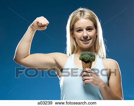 Studio portrait of young woman holding broccoli ice cream View Large Photo Image Stock Photo - Studio portrait of young woman holding broccoli ice cream. Fotosearch