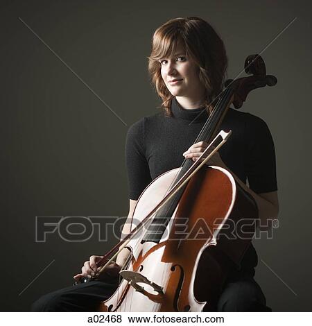 Studio portrait of young woman with cello View Large Photo Image Stock Photo - Studio portrait of young woman with cello. Fotosearch