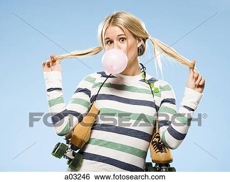 Stock Photograph - Studio portrait of young woman with roller skates. Fotosearch