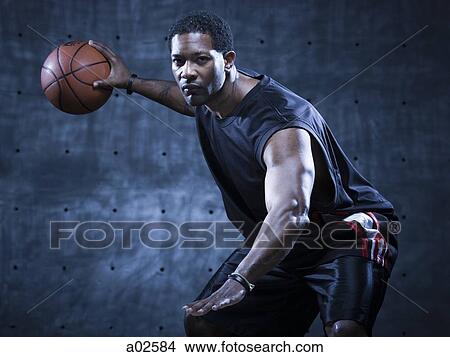 Studio shot of basketball player holding ball View Large Photo Image Picture - Studio shot of basketball player holding ball. Fotosearch