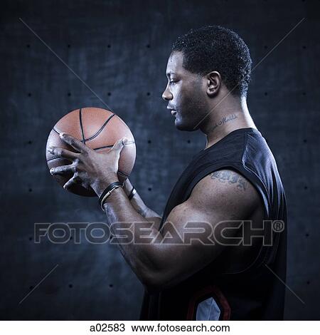 Studio shot of basketball player holding ball View Large Photo Image Stock Image - Studio shot of basketball player holding ball. Fotosearch